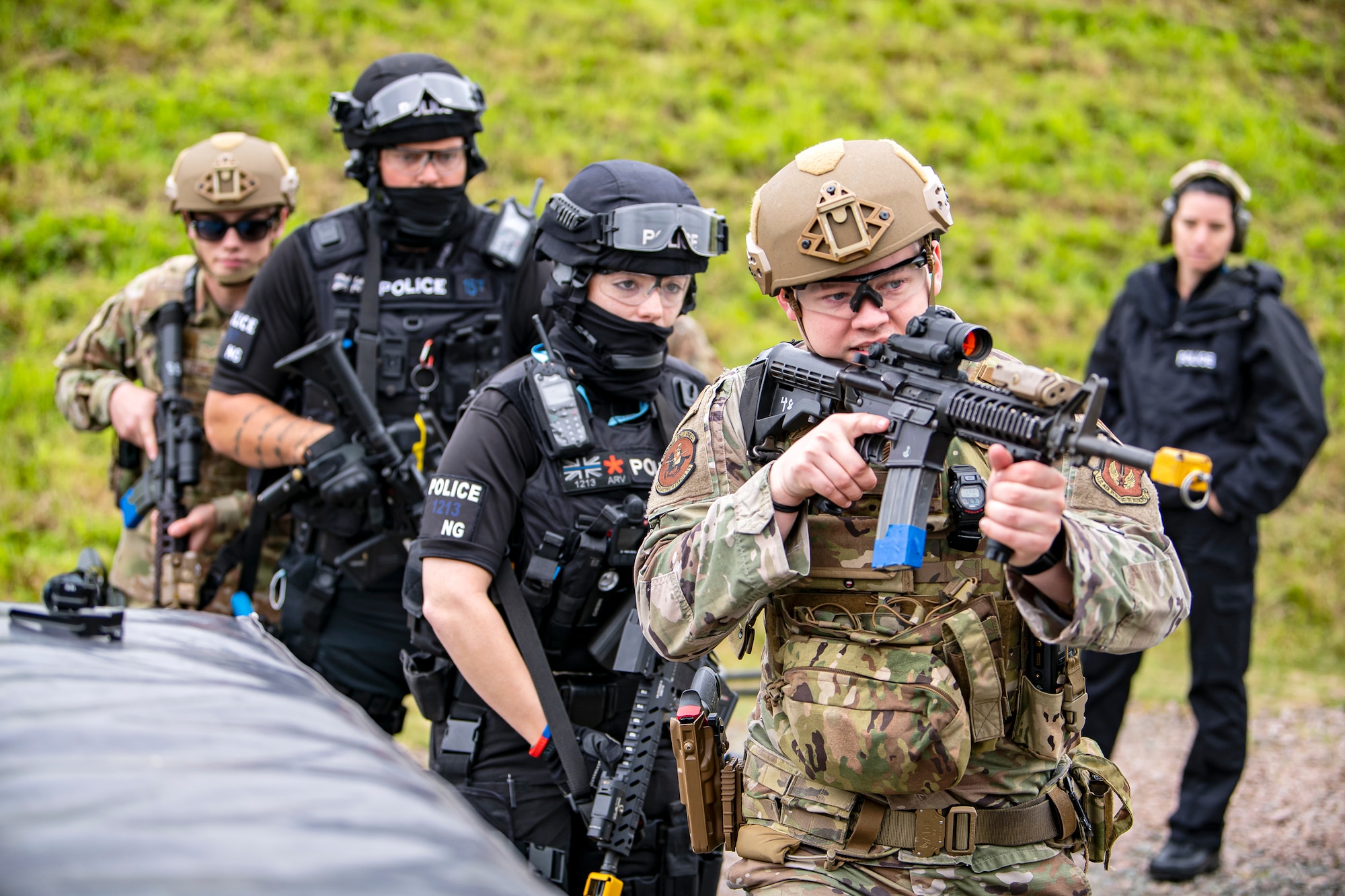 Airmen from the 422nd Security Forces Squadron, along with police officers from the Northamptonshire police department, advance their position during a tri-agency active shooter response exercise at RAF Croughton, England, June 30, 2021. Airmen from the 422nd SFS along with police officers from the NHPD and Ministry of Defense, participated in multiple exercises to enhance their search and seizure tactics, strengthen local ties and gain rapport with their fellow officers. (U.S. Air Force photo by Senior Airman Eugene Oliver)