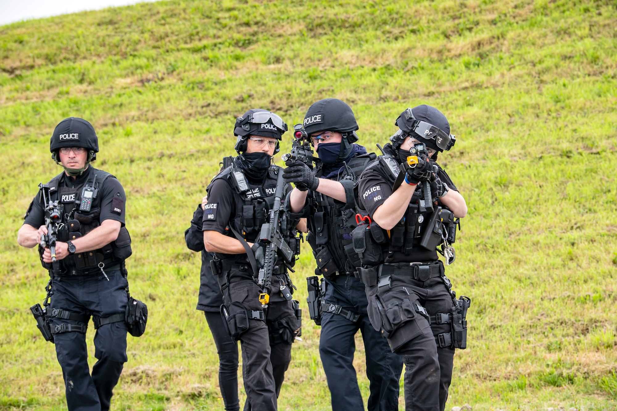 Police officers from the Northamptonshire Police Department advance their position during a tri-agency active shooter response exercise at RAF Croughton, England, June 30, 2021. Airmen from the 422nd Security Forces Squadron along with police officers from the NHPD and Ministry of Defense, participated in multiple exercises to enhance their search and seizure tactics, strengthen local ties and gain rapport with their fellow officers. (U.S. Air Force photo by Senior Airman Eugene Oliver)