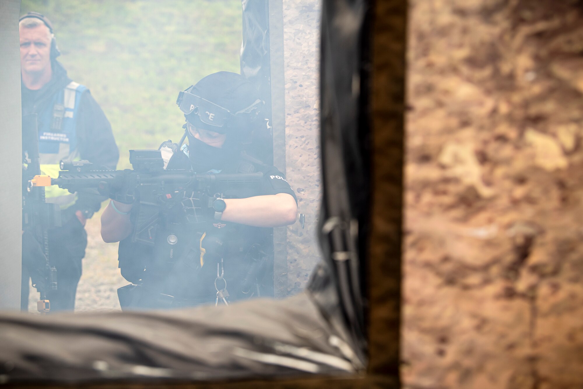 A Police officer from the Northamptonshire Police Department scans her perimeter during a tri-agency active shooter response exercise at RAF Croughton, England, June 30, 2021. Airmen from the 422nd Security Forces Squadron along with police officers from the NHPD and Ministry of Defense, participated in multiple exercises to enhance their search and seizure tactics, strengthen local ties and gain rapport with their fellow officers. (U.S. Air Force photo by Senior Airman Eugene Oliver)