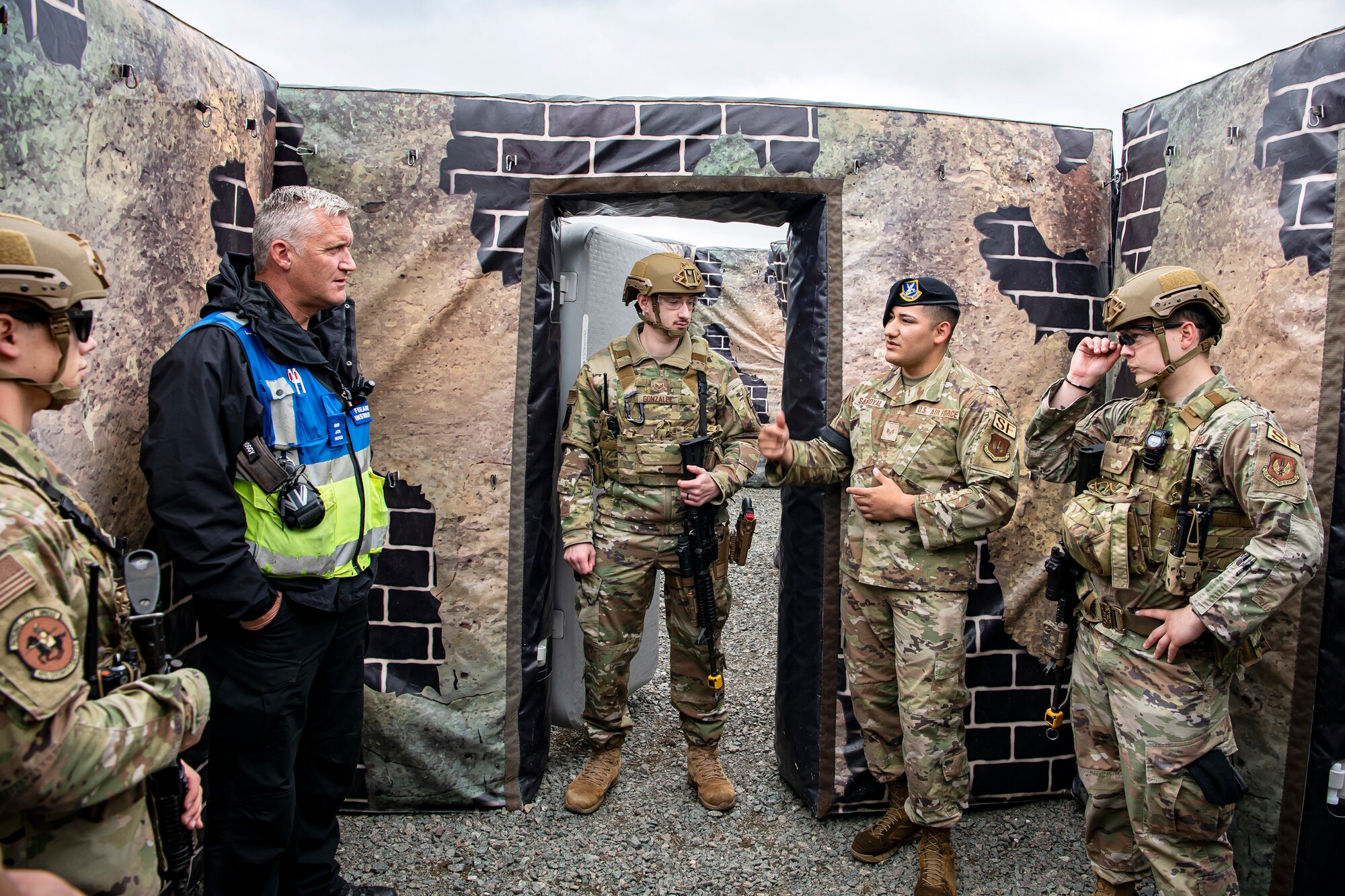 Staff Sgt. Carlos Sandoval, center right, 422nd Security Forces Squadron unit trainer, speaks with John Hogg, center left, Northamptonshire Police Department firearms instructor, following a tri-agency active shooter response exercise at RAF Croughton, England, June 30, 2021. Airmen from the 422nd SFS along with police officers from the NHPD and Ministry of Defense, participated in multiple exercises to enhance their search and seizure tactics, strengthen local ties and gain rapport with their fellow officers. (U.S. Air Force photo by Senior Airman Eugene Oliver)
