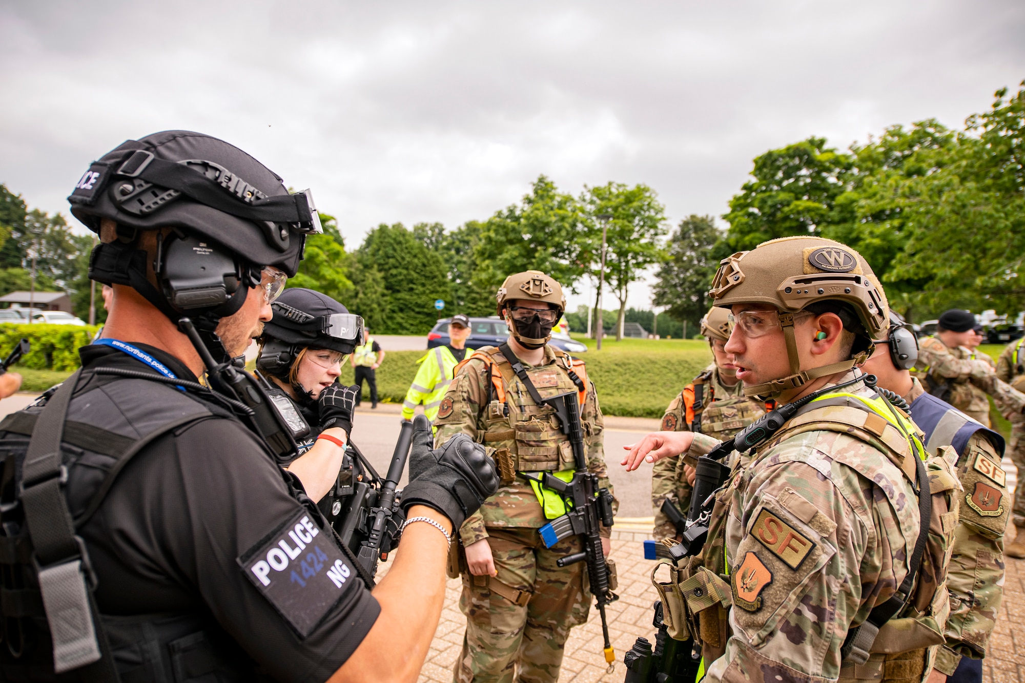 A police officer from the Northamptonshire police department, left, discusses strategy with Airmen from the 422nd Security Forces Squadron prior to a tri-agency active shooter response exercise at RAF Croughton, June 30, 2021. Airmen from the 422nd SFS along with police officers from the NHPD and Ministry of Defense, participated in multiple exercises to enhance their search and seizure tactics, strengthen local ties and gain rapport with their fellow officers. (U.S. Air Force photo by Senior Airman Eugene Oliver)