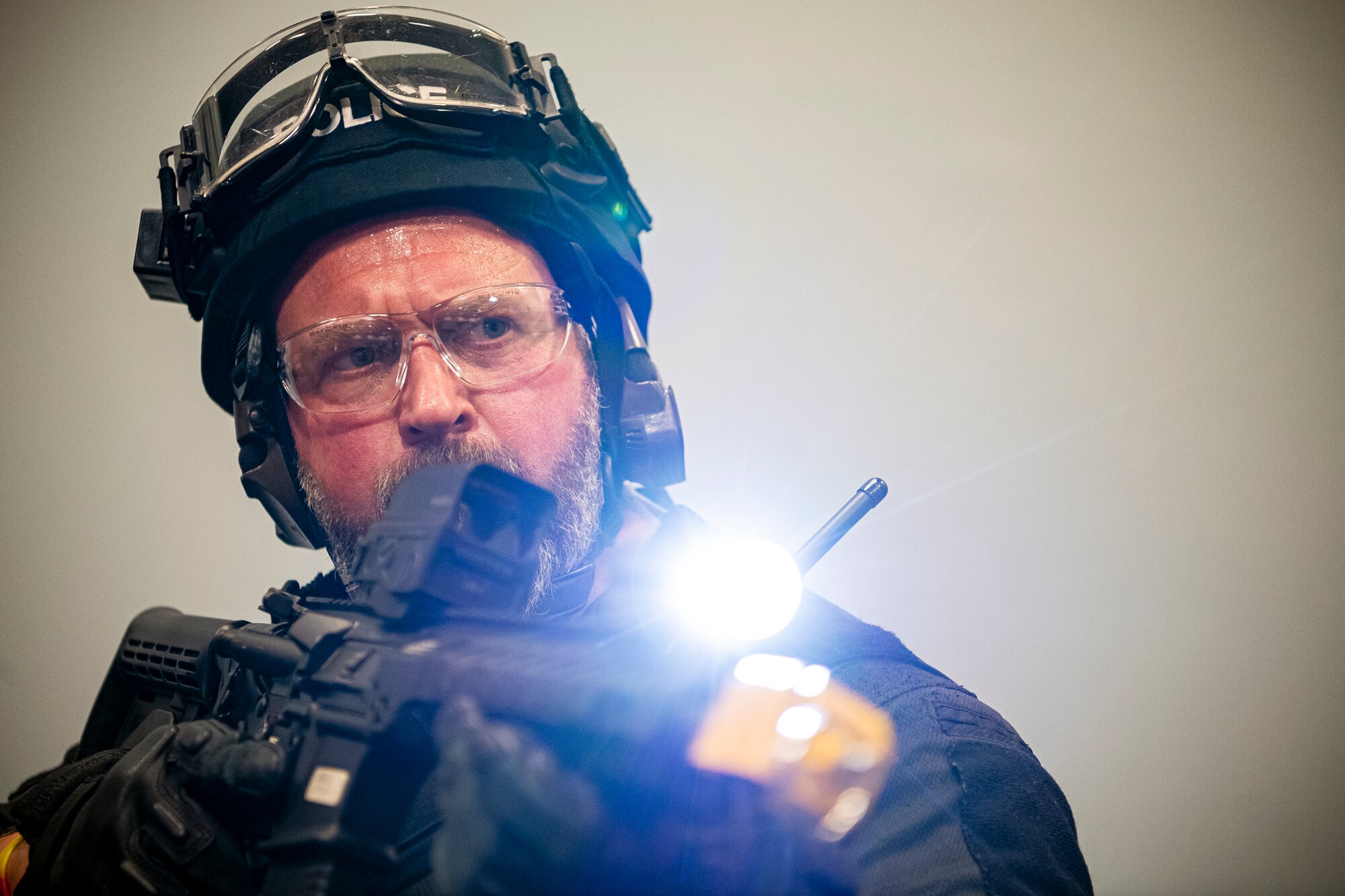 A police officer from the 422nd Security Forces Squadron, scans for adversaries during a tri-agency active shooter response exercise at RAF Croughton, England, June 30, 2021. Airmen from the 422nd Security Forces Squadron along with police officers from the NHPD and Ministry of Defense, participated in multiple exercises to enhance their search and seizure tactics, strengthen local ties and gain rapport with their fellow officers. (U.S. Air Force photo by Senior Airman Eugene Oliver)