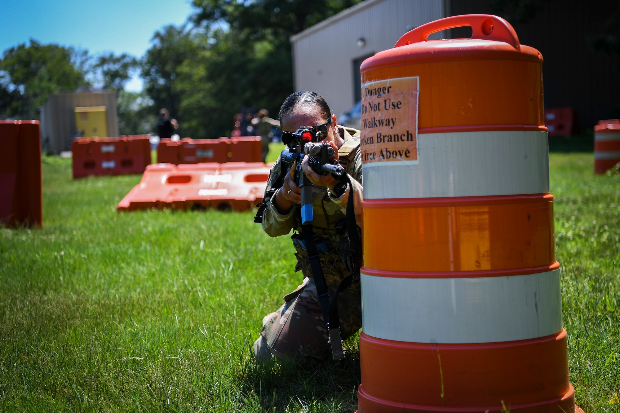 Senior Airman Adrianna Williams, 66th Security Forces Squadron entry controller, shoots from behind a blockade while wearing female body armor during a tactical exercise at Hanscom Air Force Base, Mass., June 29.  The newest development in Air Force body armor is designed to better protect female Airmen during combat and contingency operations. (U.S. Air Force photo by Lauren Russell)