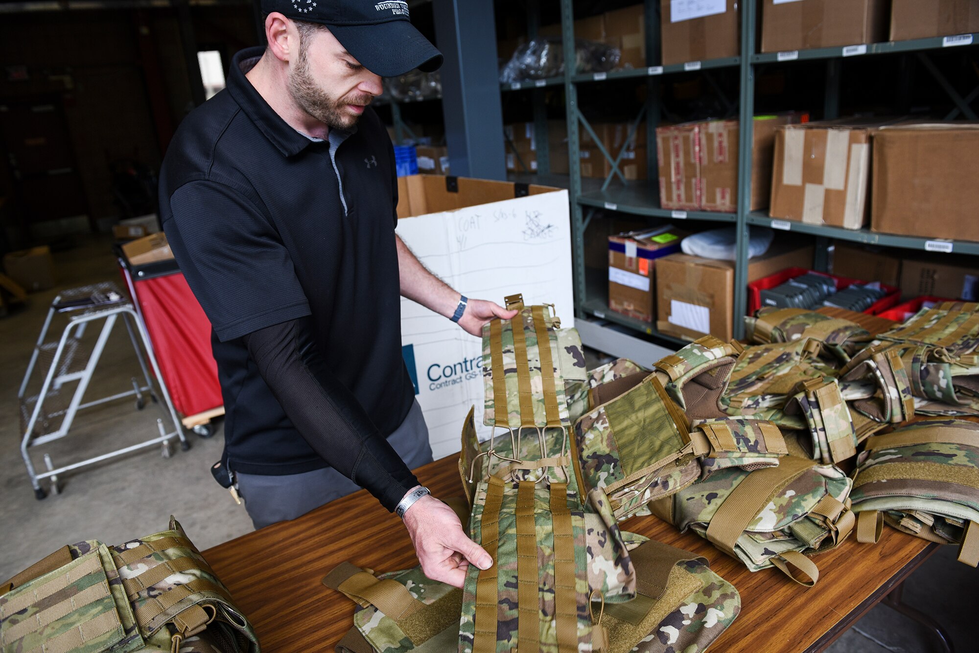 Matt Turcotte, 66th Logistic Readiness Squadron mobility manager, lays out individual sets of female body armor at Hanscom Air Force Base, Mass., June 16. The newly developed armor better forms to the female torso and provides greater protection to vital organs. (U.S. Air Force photo by Lauren Russell)