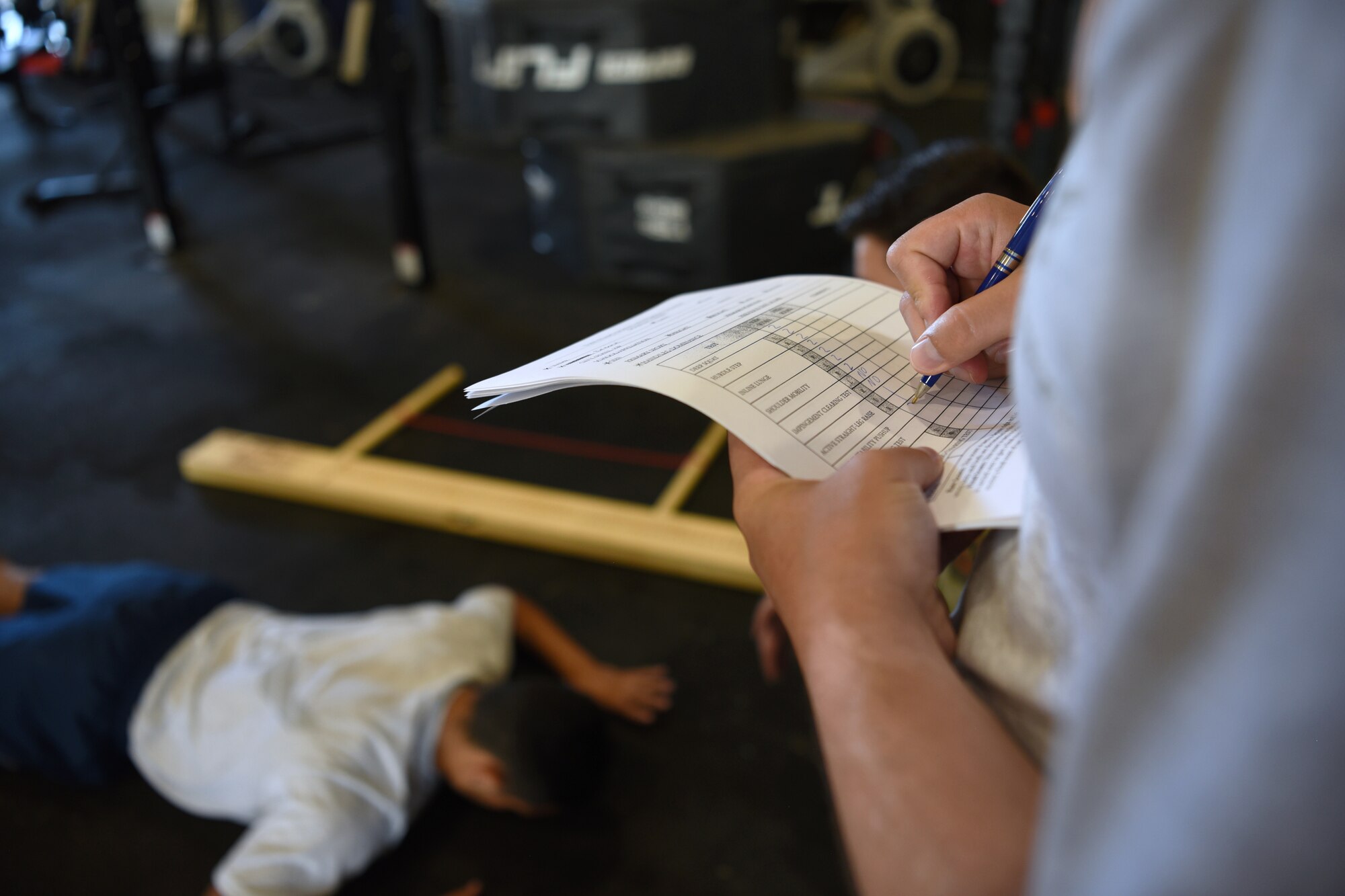 A student assigned to the 312th Training Squadron records the functional movements of another student during an evaluation on Goodfellow Air Force Base, Texas, June 30, 2021. Joint service members were evaluated before starting their firefighting training to identify biopsychosocial factors that could detract from the success of their training. (U.S. Air Force photo by Senior Airman Abbey Rieves)