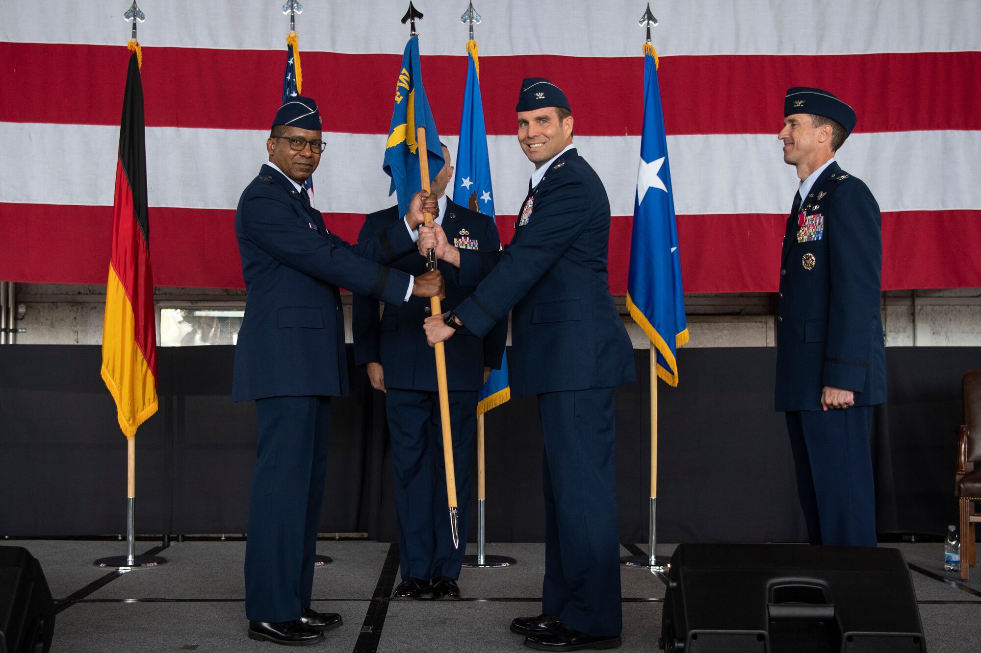 U.S. Air Force Maj. Gen. Randall Reed, Third Air Force commander (left), passes the guidon to Col. Leslie Hauck, 52nd Fighter Wing incoming commander July 15, 2021, on Spangdahlem Air Base, Germany. Hauck comes from Aviano Air Base, Italy, where he served as the commander of the 31st Operations Group. (U.S. Air Force photo by Staff Sgt. Melody W. Howley)