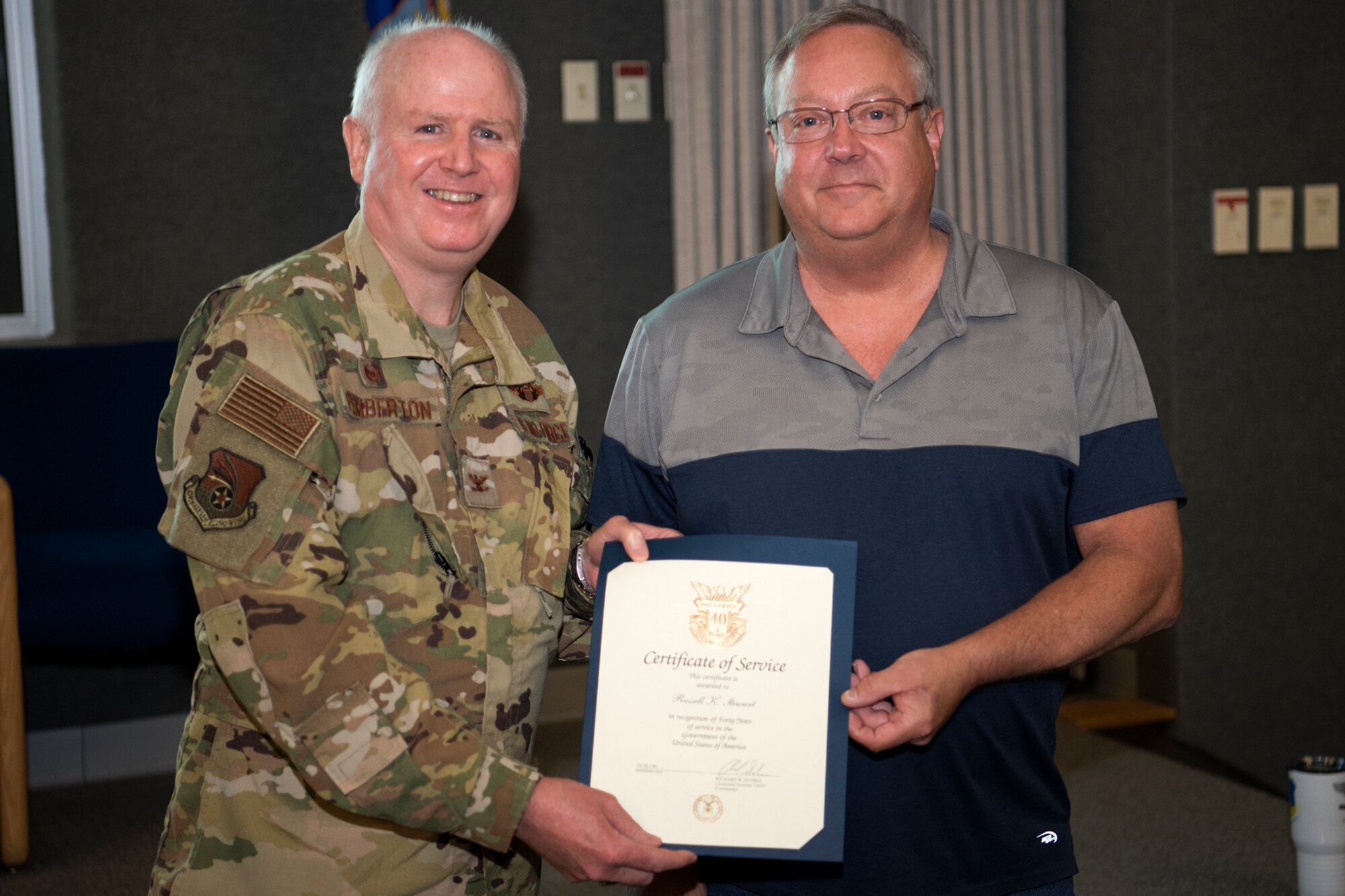 Col. Thom Pemberton, 434th Air Refueling Wing commander, left, presents Rusty Stewart, 434th Maintenance Squadron, a certificate recognizing his 40 years of federal service July 8, 2021. Employees were recognized during a civilian commander's call for 40, 30, 20, and 10 years of service. (U.S. Air Force photo by Douglas Hays)