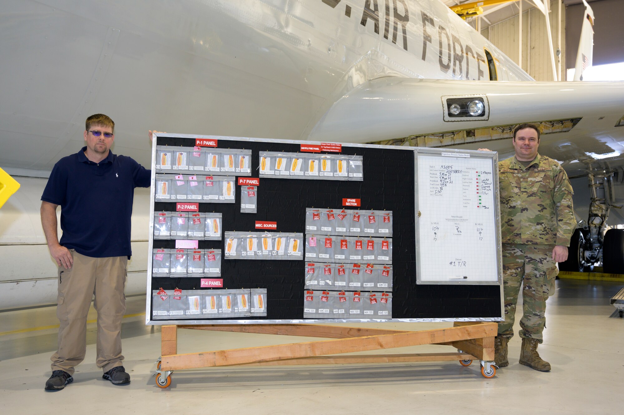 Nathan Giadrosich, left, an isochronal (ISO) maintenance technician and Master Sgt. Clifford Singleton, an ISO inspector with the 116th Maintenance Squadron, Georgia Air National Guard, stand beside a paperless process status board as part of the innovative ISO inspection process at Robins Air Force Base, Georgia, May 14, 2021. ISO inspections are in-depth inspections that are conducted every 18 months to ensure aircraft are properly maintained and mission ready. (U.S. Air National Guard photo by Airman 1st Class Josiah Meece).