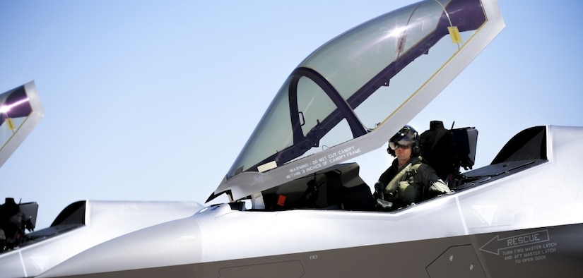 A pilot sits in the cockpit of a jet.