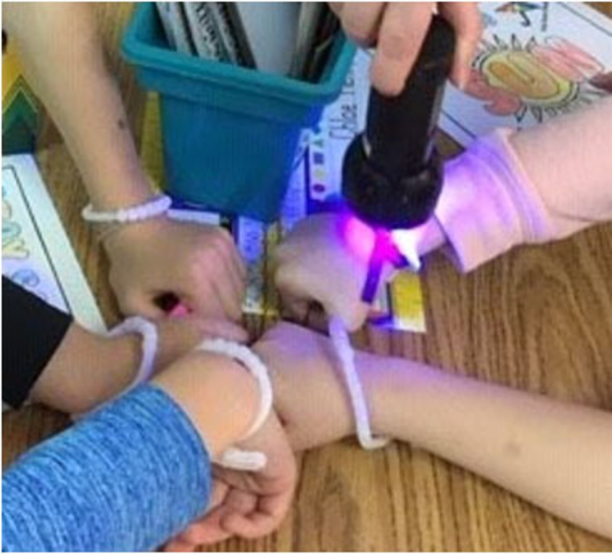 First-grade students in the Wizards of Wright! program use ultraviolet beads to show the effect of UV rays during an outreach lesson in April.