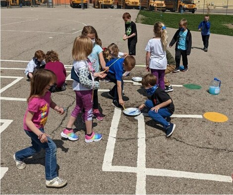 Students at Shaw Elementary School in Beavercreek learn about molecules, cohesion and surface tension using the “bubbles and water” lesson as part of the Wizards of Wright! Presentation in April.