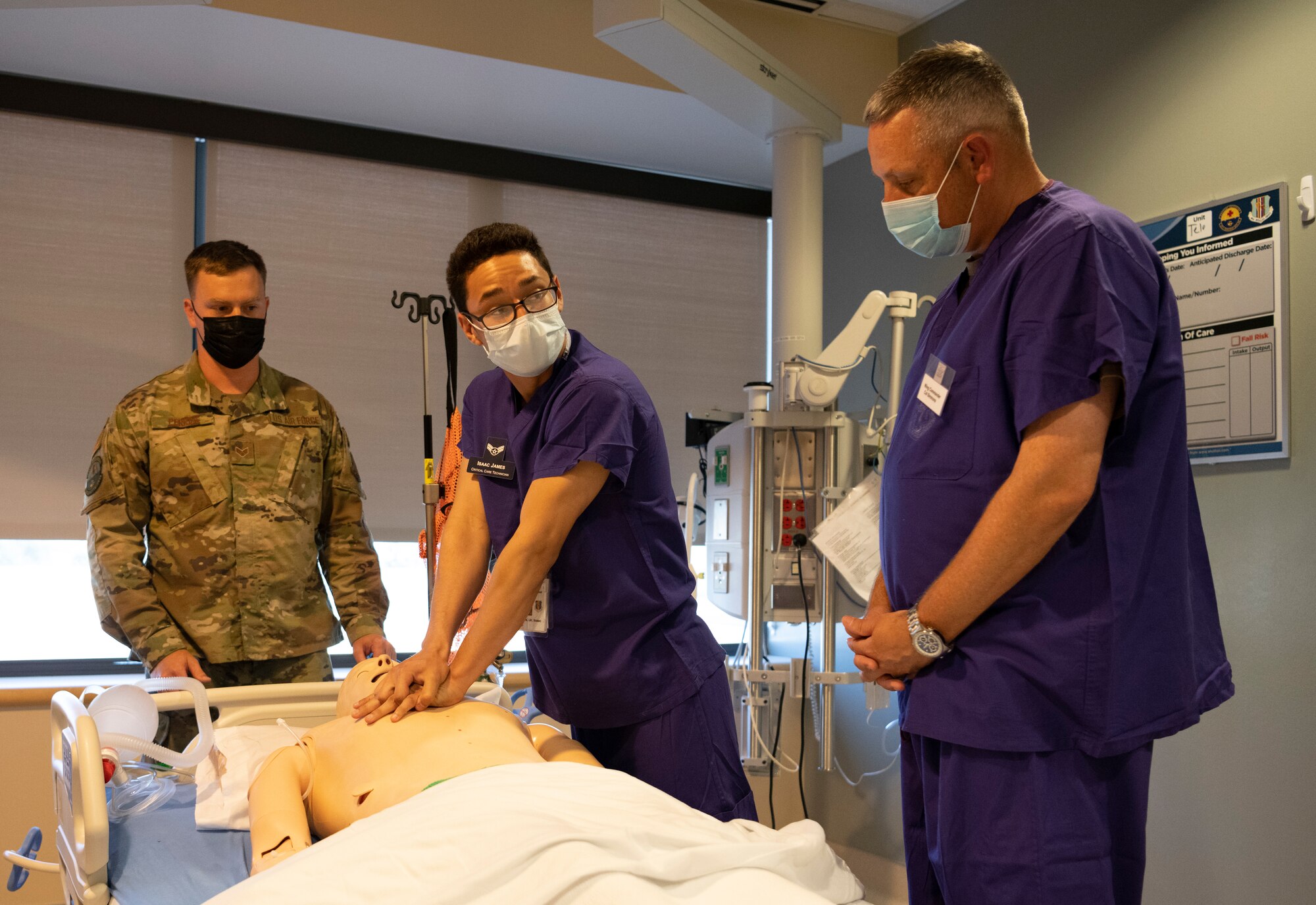 Airman giving chest compressions to a mannequin