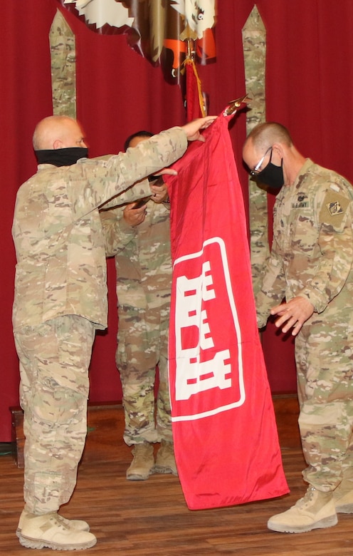 Task Force Essayons colors wave for the final time at Camp Arifjan, Kuwait as the outgoing command team of Colonel John Haas, Jr, and SGM William Klaers prepare the flag to be cased. (Photo by Rick Benoit)