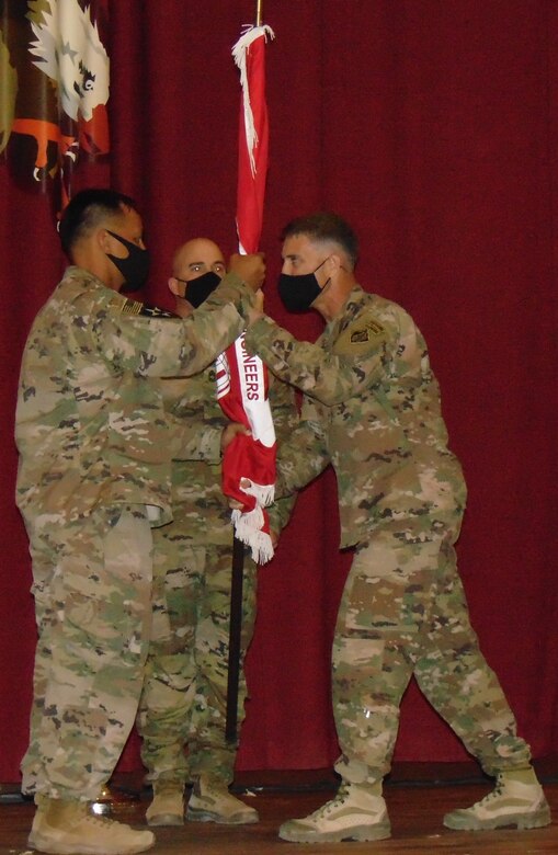 Colonel Mark A. Geraldi passes the colors of the Transatlantic Expeditionary District to the incoming Senior Enlisted Advisor, Sergeant Major Jun C. Tomagan as the outgoing Advisor, Ron Brown looks on. (Photo by Cecilia Polanco)