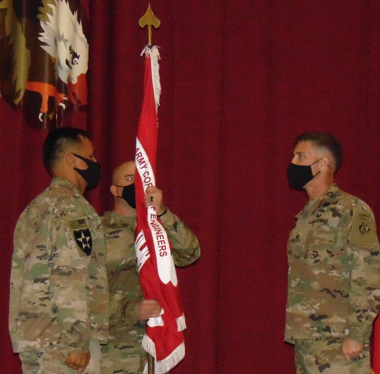 Colonel Mark A. Geraldi passes the colors of the Transatlantic Expeditionary District to the incoming Senior Enlisted Advisor, Sergeant Major Jun C. Tomagan as the outgoing Advisor, Ron Brown looks on. (Photo by Cecilia Polanco)