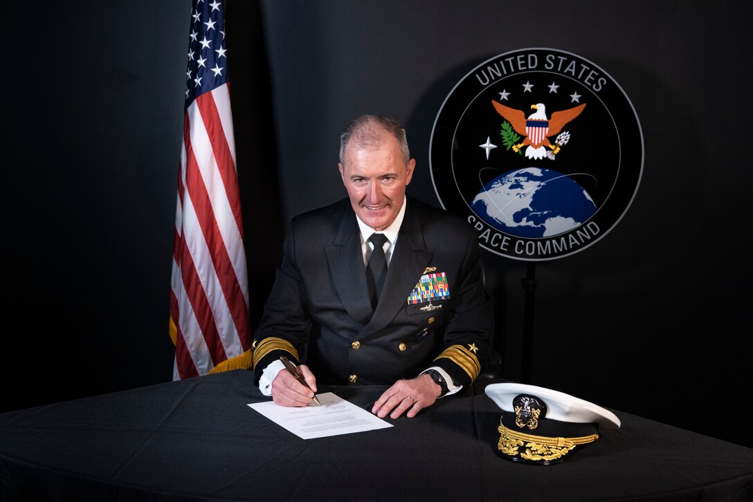 Navy admiral signs a document