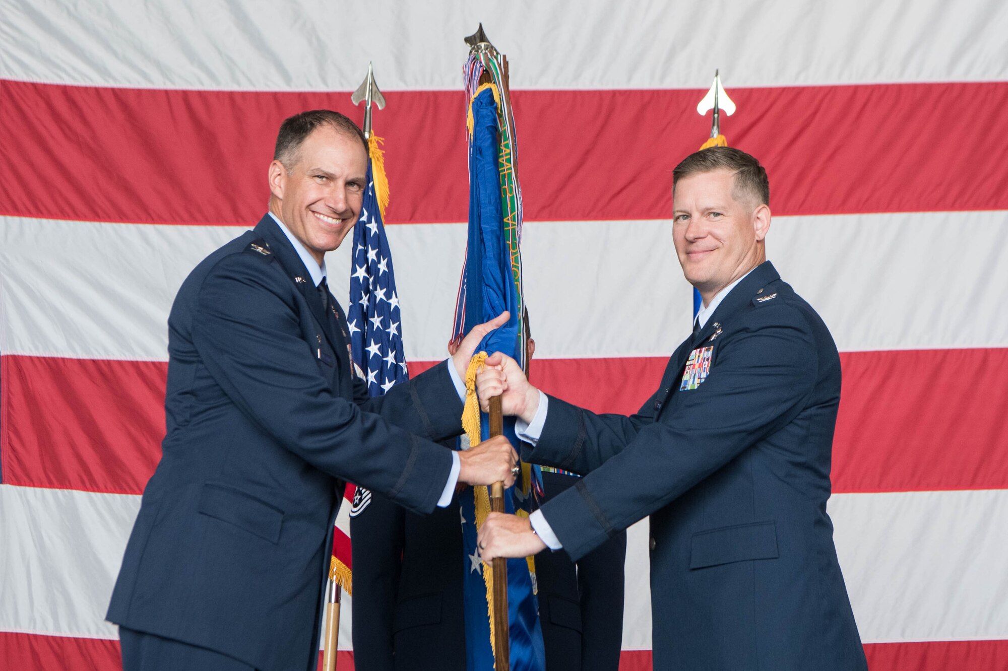 Col. Matthew Husemann, left, 436th Airlift Wing commander passes the guidon to Col. Scott Raleigh, incoming 436th Operations Group commander, during a change of command ceremony at Dover Air Force Base, Delaware, July 15, 2021. The ceremony saw Peeler relinquish command to Col. Scott Raleigh. The 436th OG operates Dover AFB’s fleet of C-5M Super Galaxy and C-17 Globemaster III aircraft supporting rapid global mobility. (U.S. Air Force photo by Mauricio Campino)