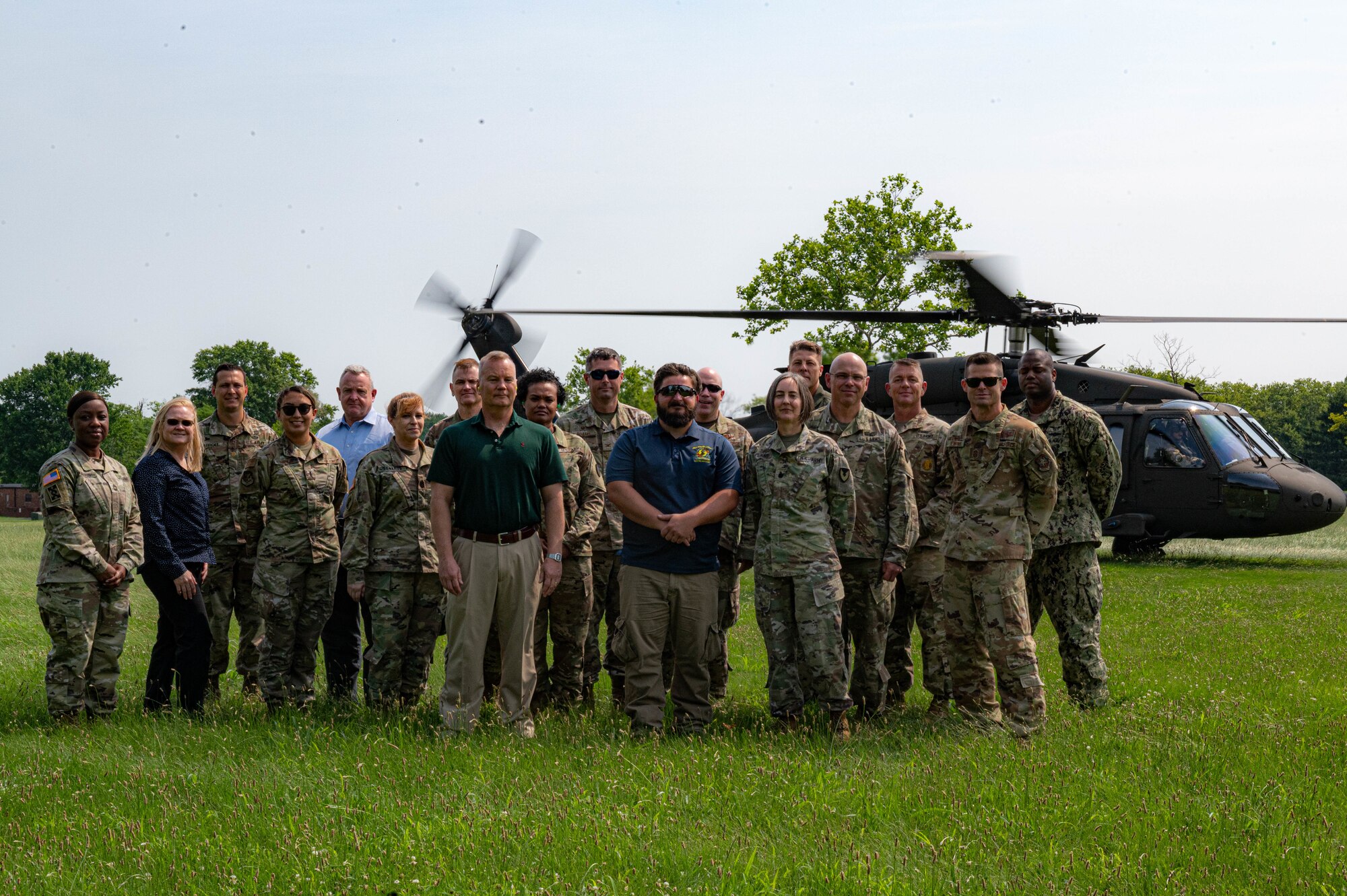 Service members pose for a photo in front of a UH-60 Blackhawk