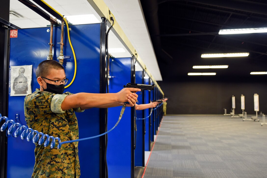 A Navy ROTC midshipman candidate fires a weapon.