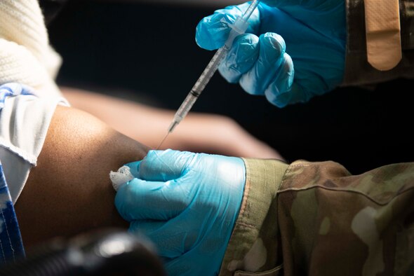 U.S. Air Force Tech. Sgt. Edric Johnson, an El Paso, Texas, native and vaccinator assigned to the 335th Expeditionary Medical Operations Squadron, vaccinates a community member at a Community Vaccination Center in Brooklyn, New York, on March 22, 2021. Johnson is deployed from the 56th Medical Group out of Luke Air Force Base, Arizona, and is one of approximately 140 Airmen across 28 installations deployed to the Brooklyn CVC in support of U.S. Army North’s COVID-19 response efforts. U.S. Northern Command, through U.S. Army North, remains committed to providing continued, flexible Department of Defense support to the Federal Emergency Management Agency as part of the whole-of-government response to COVID-19. (U.S. Air Force photo by Tech. Sgt. Ashley Nicole Taylor)