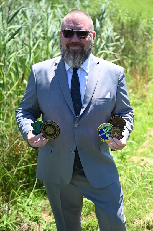 Ryan Collins holds patches he help design.