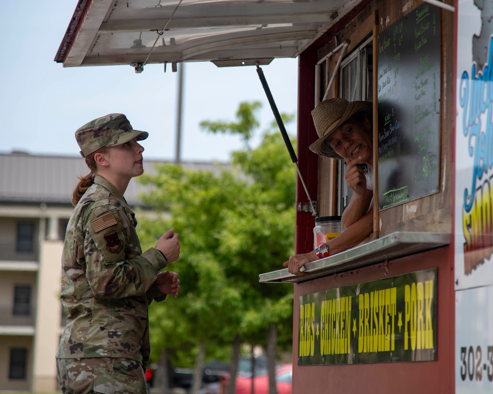 Airman 1st Class Cydney Lee, 436th Airlift Wing Public Affairs specialist, purchases a meal from a food truck in front of the Patterson Dining Facility at Dover Air Force Base, Delaware, July 15, 2021. The DFAC closed for renovations on its electrical systems and walk-in refrigerator. The 436th Force Support Squadron coordinated bringing various food trucks onto Dover AFB to provide options for Airmen during the closure. (U.S. Air Force photo by Tech. Sgt. J.D. Strong II)