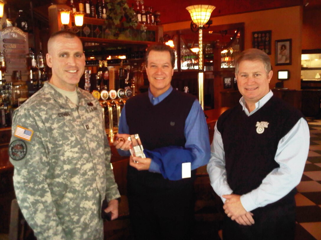 Capt. Bryan Combs, State Family Program director and Joe Brummett, Community Outreach director, give Mark Fichtner of the Lexington English Pub the Kentucky Minuteman glass award for appreciation of the support to Kentucky National Guard in Lexington, Ky., Jan. 20.