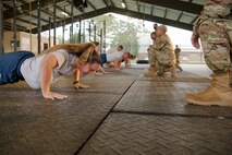 (Front left) Staff Sgt. April Prine, 919th Special Operations Logistics Readiness Squadron Individual Protective Equipment supervisor and members of the 919th Special Operations Wing participate in the Air Force physical fitness test, July 11, 2021. Each Airman are to complete as many push-ups in one minute. After completing the push-ups, the Airmen had the sit-ups requirement, and a 1.5-mile run to complete the AF physical fitness test. (U.S. Air Force photo by Michelle Gigante)