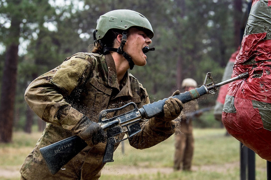 An Air Force cadet strikes a bag with the point of a training rifle.