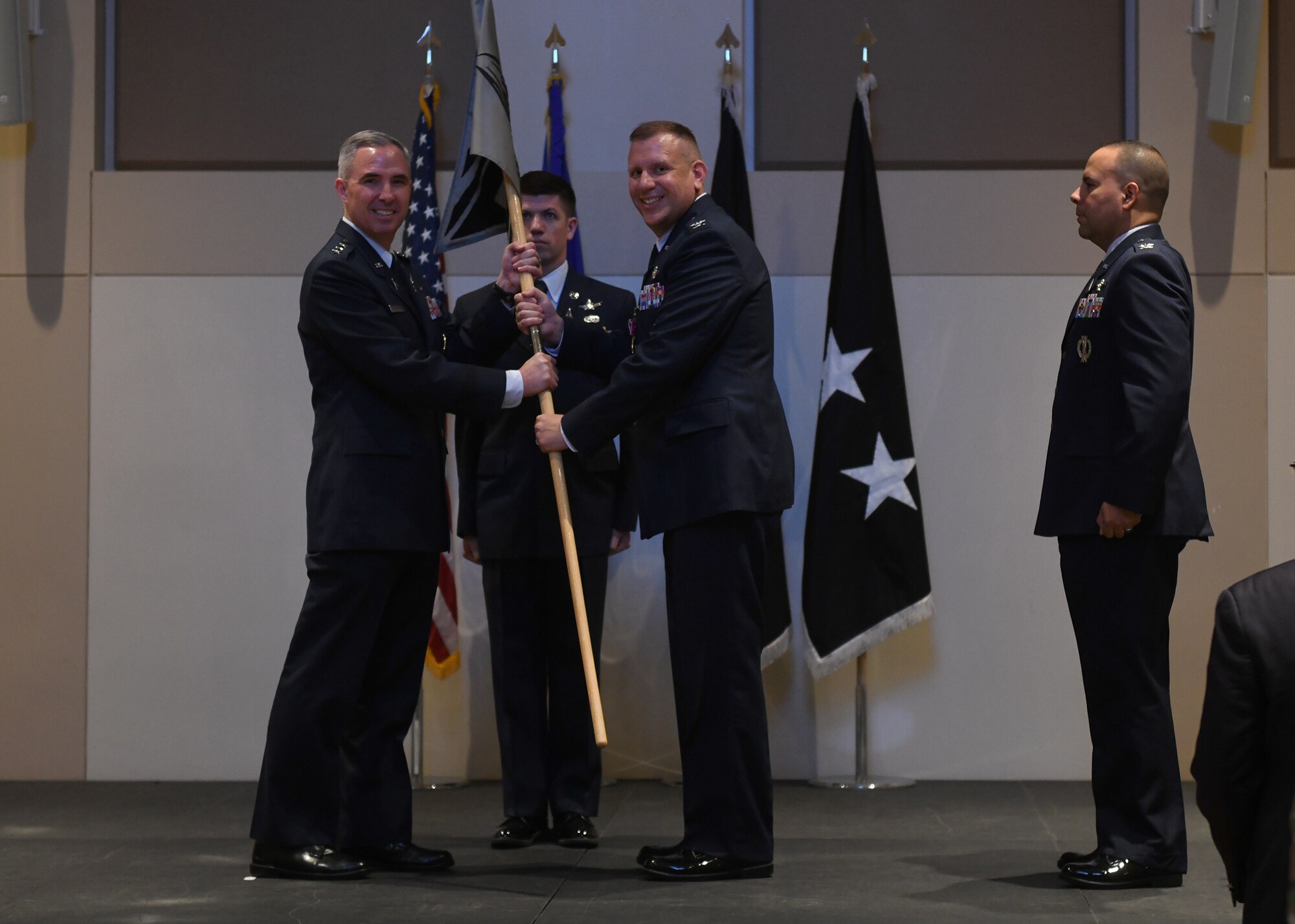 Col. Richard Bourquin, outgoing Space Delta 4 commander, passes the guidon to Lt. Gen. Stephen Whiting, Space Operations Command commander, during a change of command ceremony at Buckley Space Force Base, Colo., July 15, 2021. The passing of the guidon is a military tradition that symbolizes a transfer of command and commemorates past leadership and success of the outgoing commander. (U.S. Space Force photo by Airman 1st Class Haley N. Blevins)