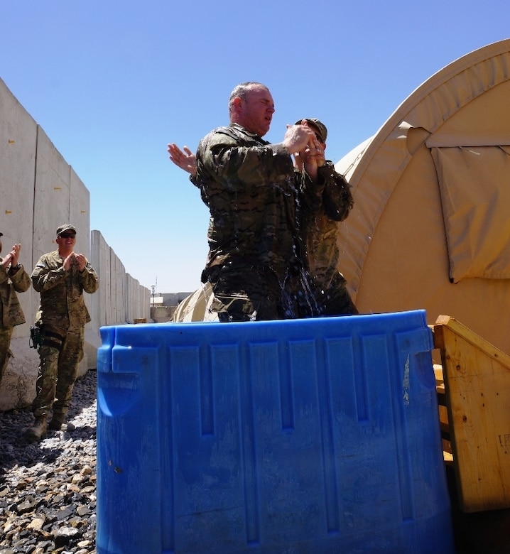 in southern Afghanistan as fellow worshipers applaud. Yankey, a soldier from the Kentucky National Guard's Agribusiness Development Team 4 celebrated his re-dedication of faith through baptism following the day's worship service.