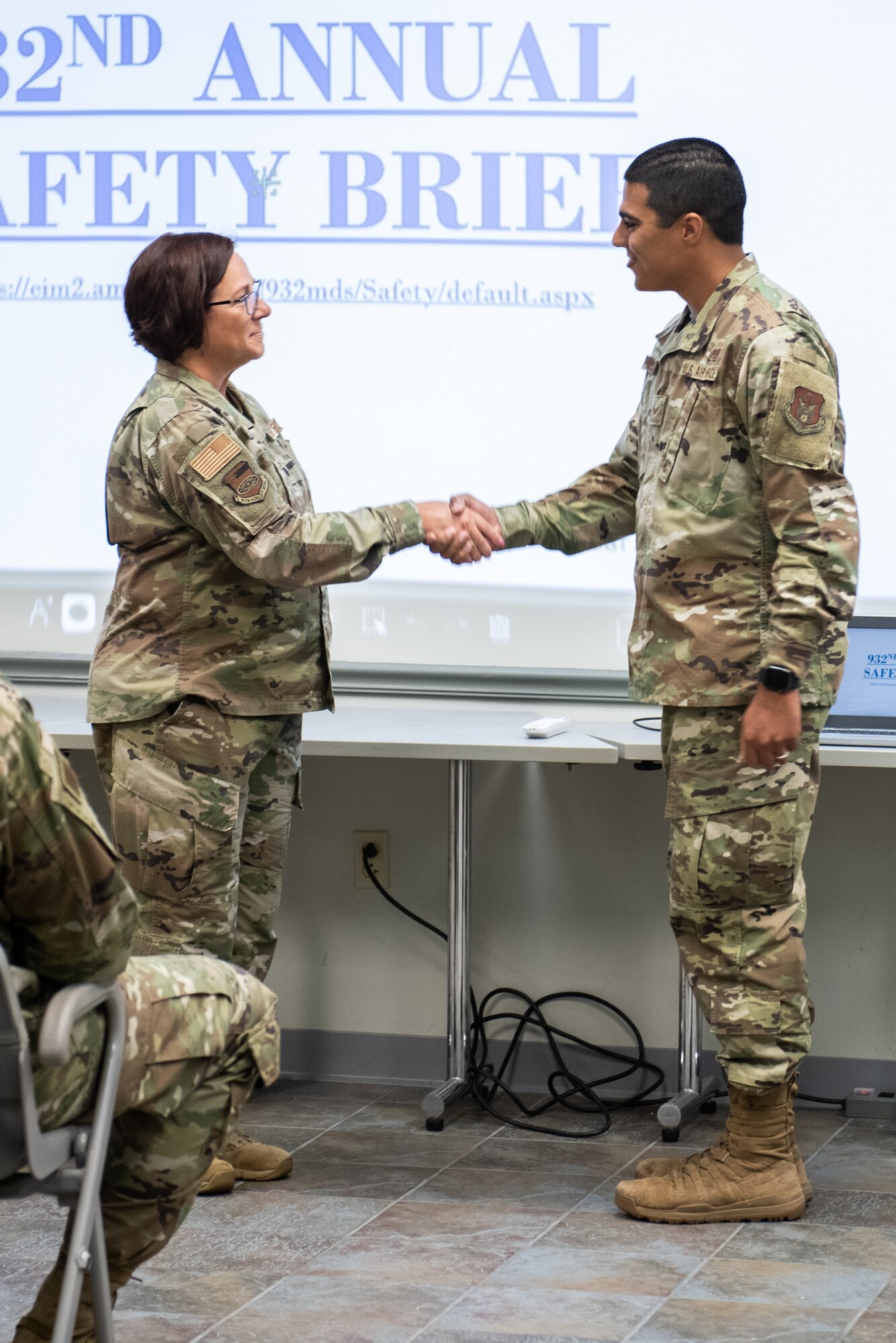 Lt. Col. Julie Novy, 932nd Airlift Wing, Inspector General Office, presents Senior Airman Warren McKeithen, 932nd AW, Medical Group, with an Inspector General coin at Scott Air Force Base, Illinois, July 10, 2021. During an active shooter drill McKeithen efficiently conducted a recall of the unit and realized there was a member who was non responsive. They simulated a death of a member and he was able to relay that one of his members was on base and was not found to the wing. McKeithen reacted to the situation properly unlike many units before him, earning him the IG coin! (U.S. Air Force Photo by Staff Sgt. Brooke Spenner)