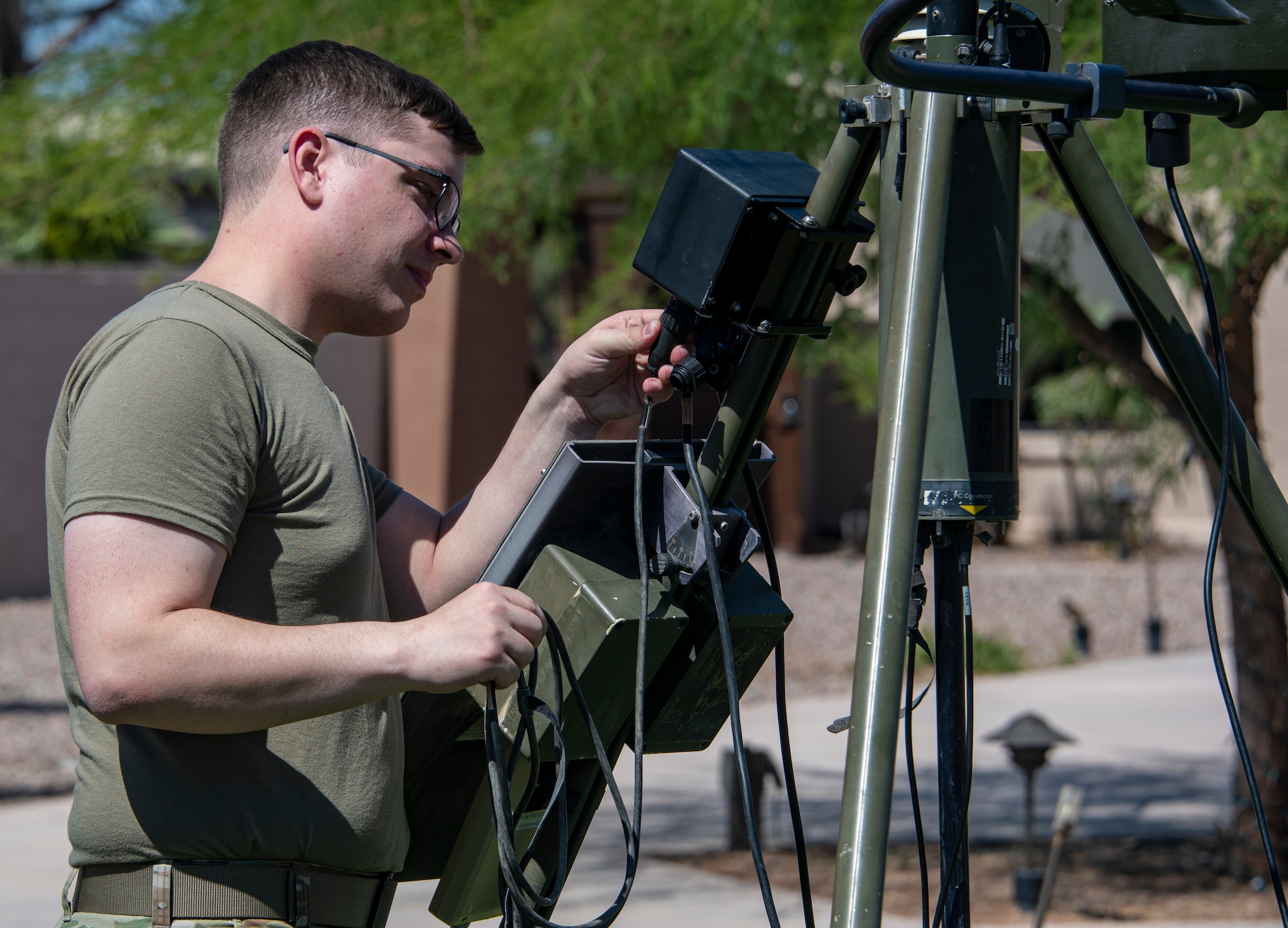 A photo of an airmen next to a weather station