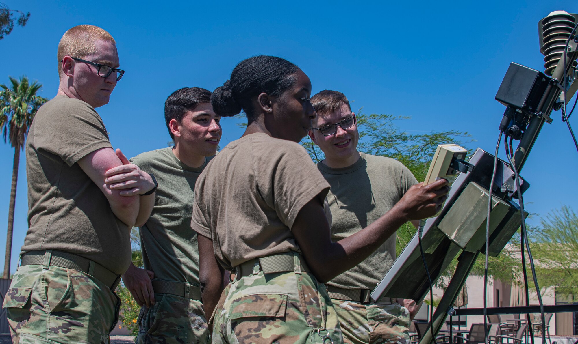 A photo of airmen next to a weather station