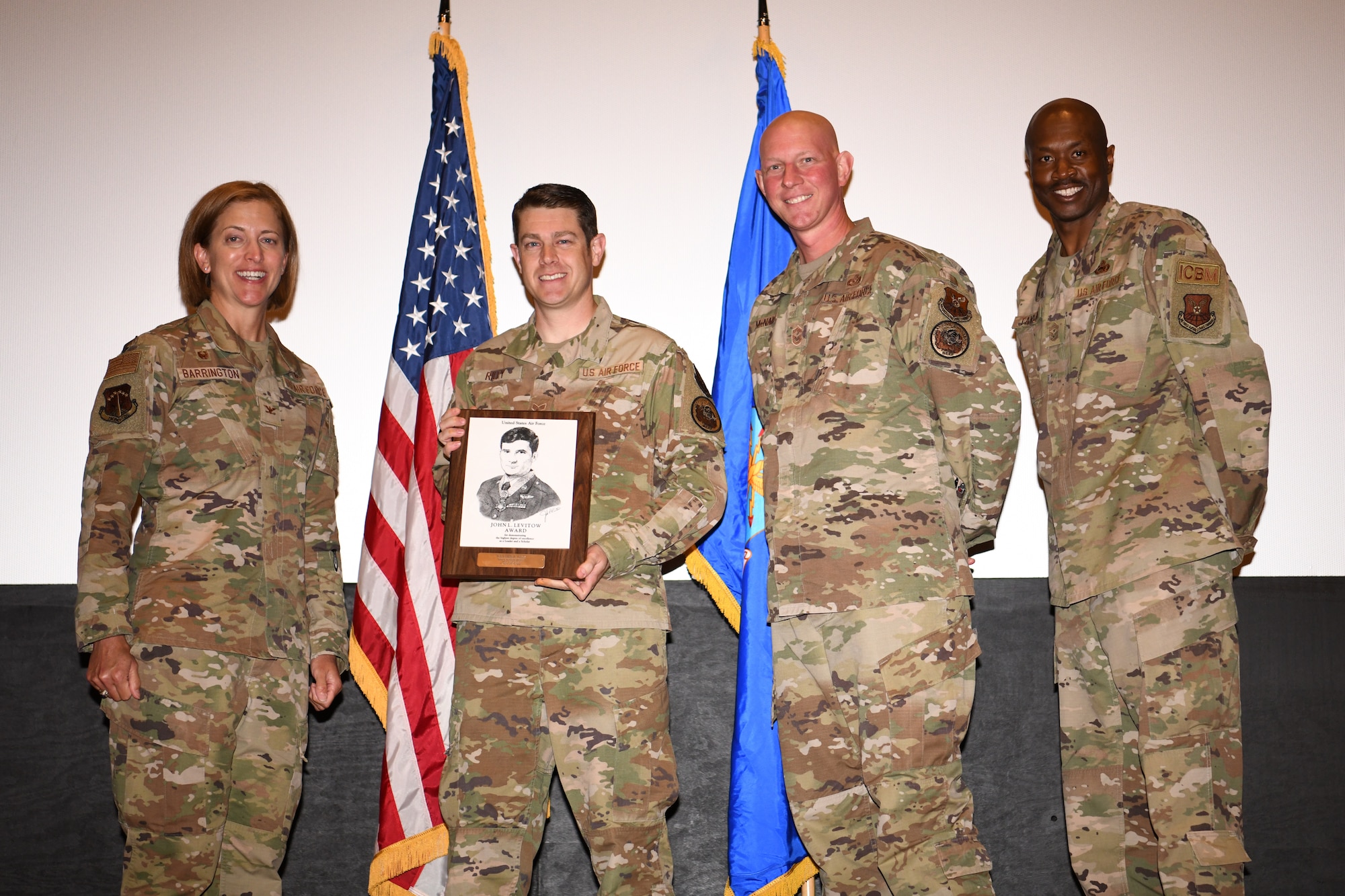 Senior Airman Donald Riley, from the 90th Civil Engineer Squadron, receives the Levitow award during the ALS graduation July 15, 2021 in the base theater on F.E. Warren Air Force Base, Wyo. The Levitow award is presented to the student that demonstrates the most outstanding leadership and scholastic qualities, based on academic performance and assignment of points by peers and instructors. (U.S. Air Force photo by Airman 1st Class Charles Munoz)