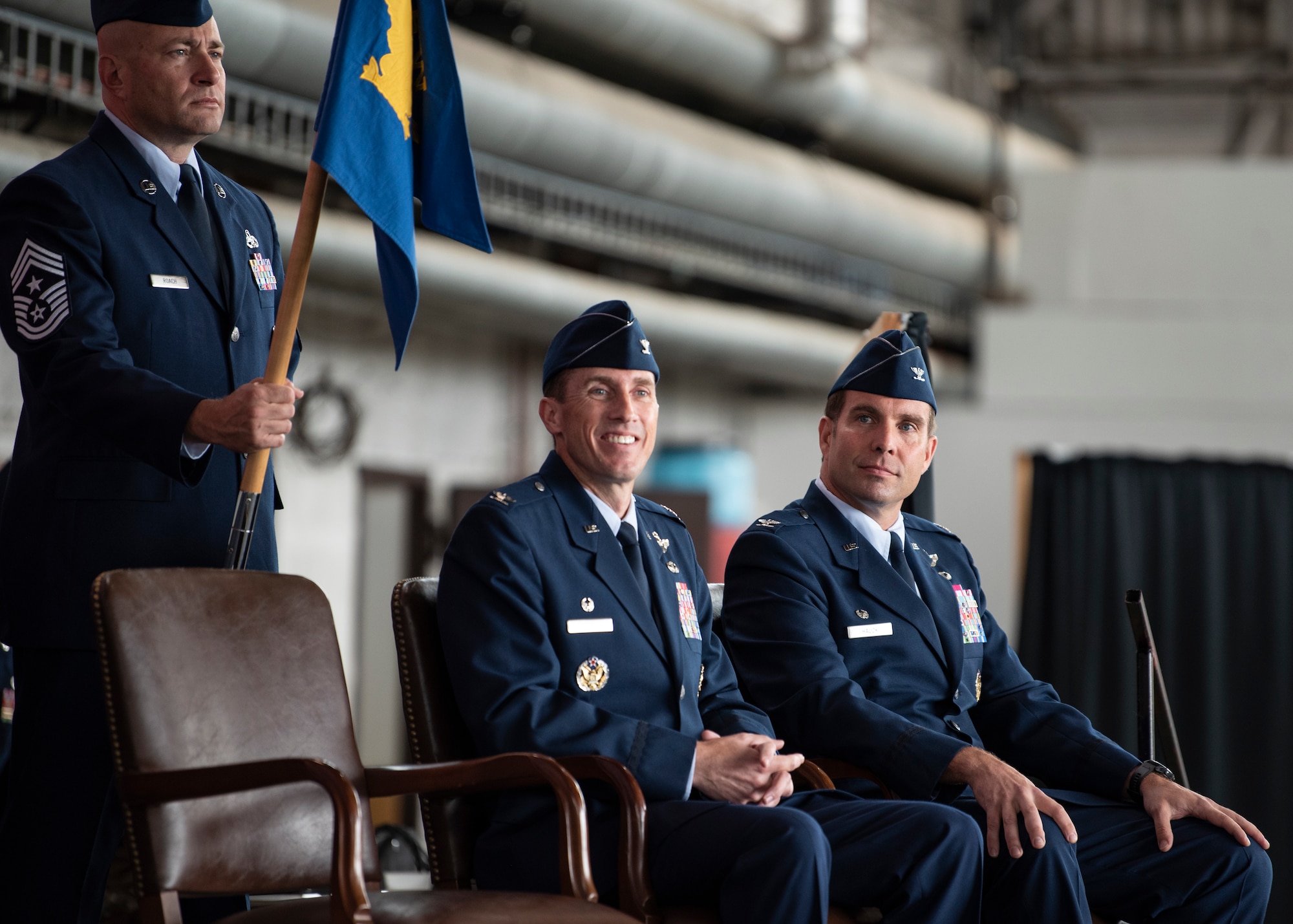 U.S. Air Force Chief Toby Roach, 52nd Fighter Wing command chief, (left), holds the guidon while Col. David Epperson, 52nd FW outgoing commander, (center), and Col. Leslie Hauck, 52nd FW incoming commander, listened to opening remarks from Maj. Gen. Randall Reed, Third Air Force commander, during the 52nd FW Change of Command ceremony July 15, 2021, on Spangdahlem Air Base, Germany. Hauck is a command pilot with more than 2,400 hours in the F-16 Fighting Falcon, including 285 combat hours in support of Operation Enduring Freedom. (U.S. Air Force photo by Staff Sgt. Melody W. Howley)