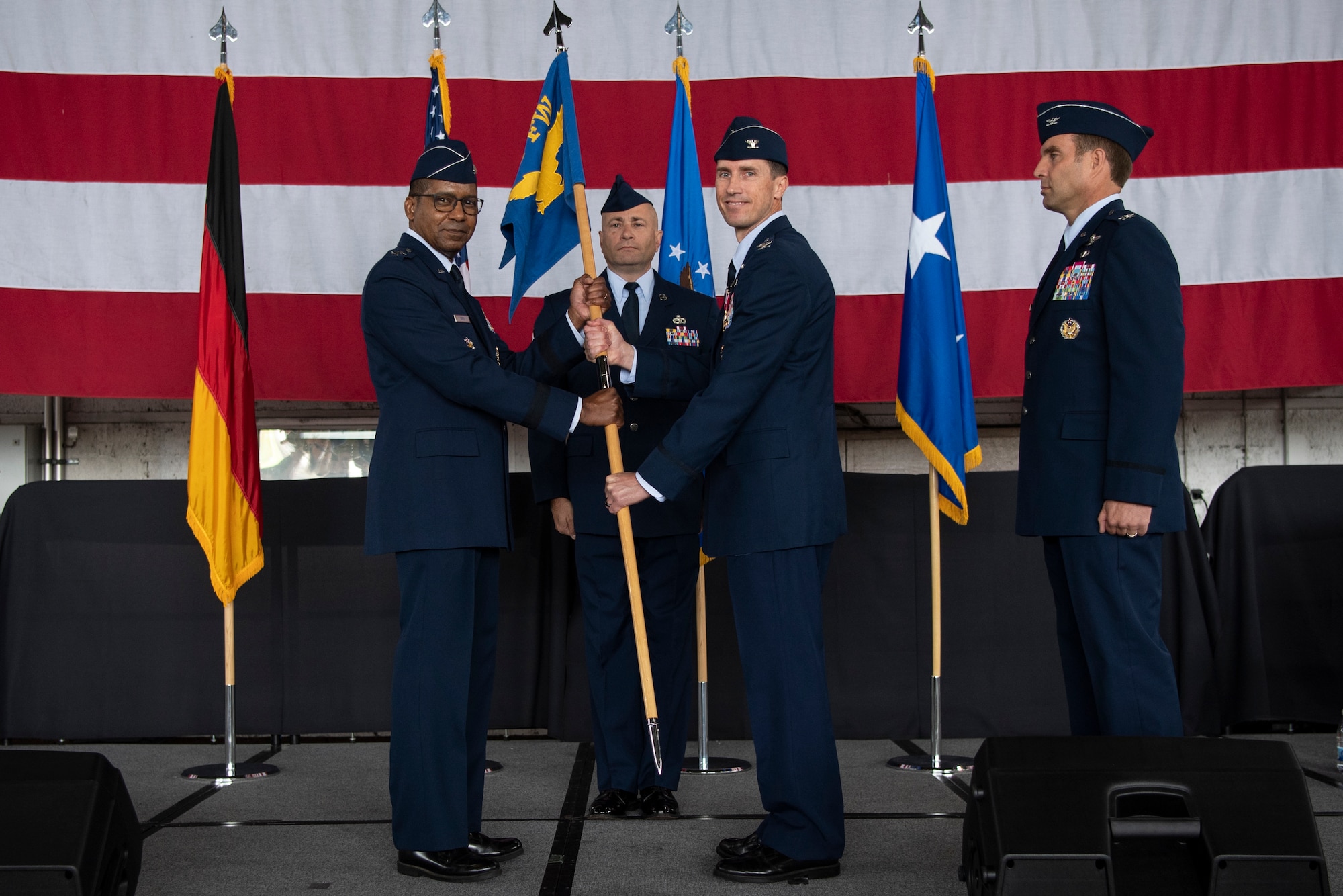 U.S. Air Force Col. David Epperson, 52nd Fighter Wing outgoing commander (center), passes the 52nd FW guidon to U.S. Air Force Maj. Gen. Randall Reed, Third Air Force commander (left), as he relinquishes command during the 52nd Fighter Wing Change of Command ceremony July 15, 2021, on Spangdahlem Air Base, Germany. The 52nd FW commander oversees all five of the wing’s groups, who directly support the mission to provide strategic, theater and contract commercial air mobility capability for Europe, Africa and Southwest Asia. (U.S. Air Force photo by Staff Sgt. Melody W. Howley)