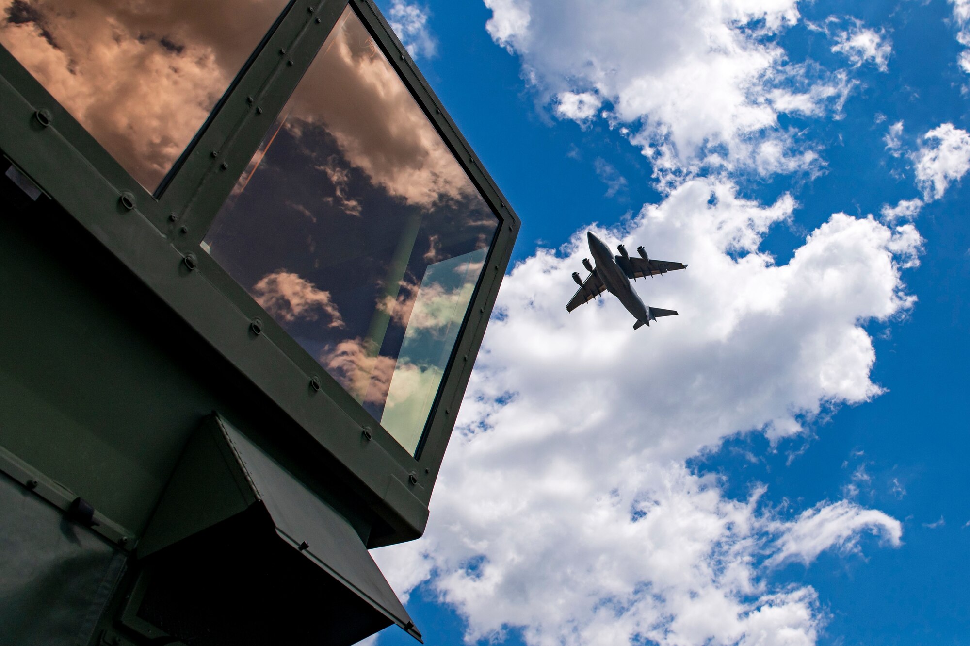 A U.S. Air Force C-17 Globemaster III from the 167th Airlift Wing, West Virginia Air National Guard, performs a low pass over a mobile air traffic control tower at Fort McCoy, Wis., June 14, 2021. PATRIOT 21 is a training exercise designed for civilian emergency management and responders to work with military entities to prepare for disasters.