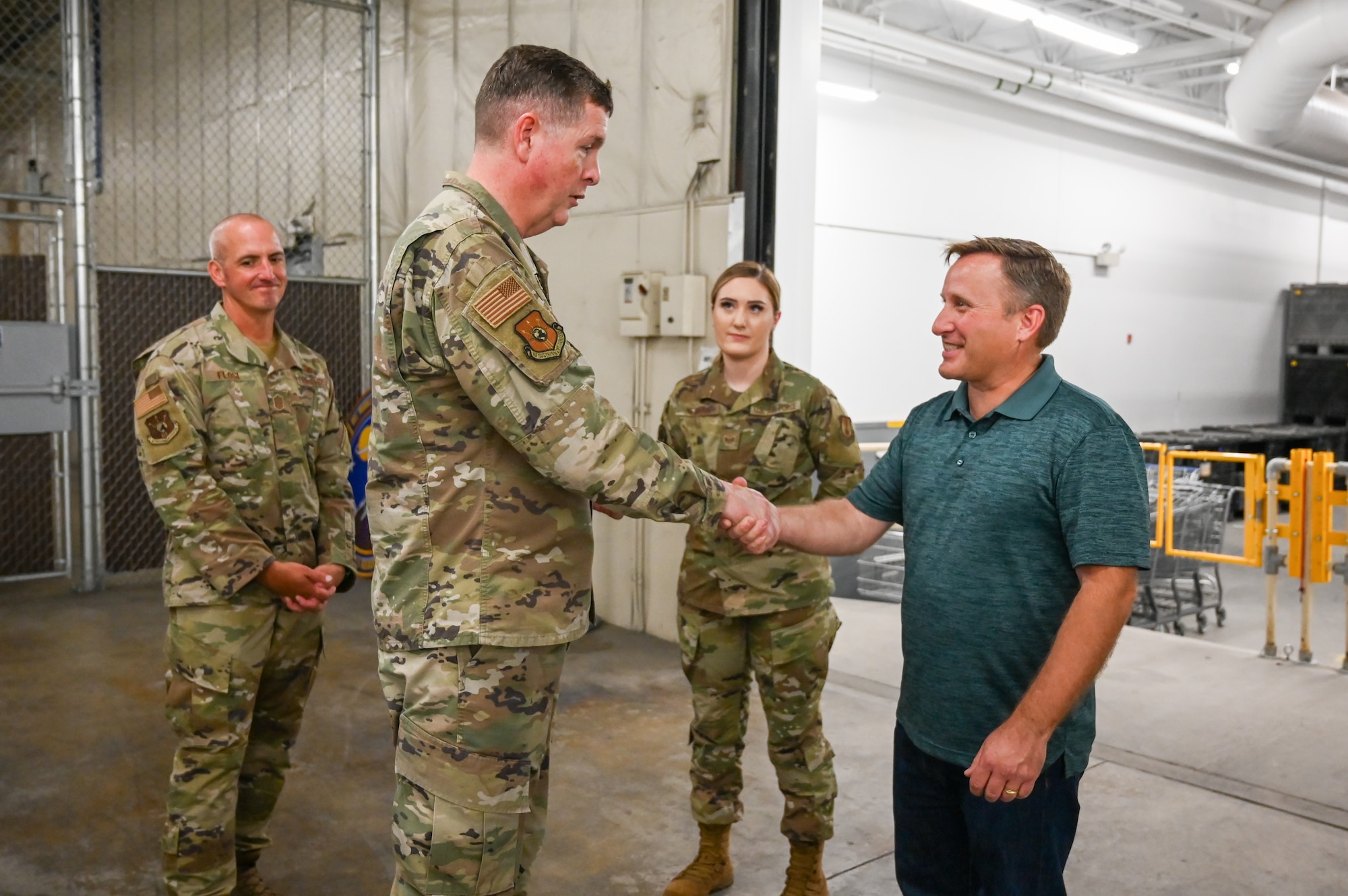 Blaine Haycock and Lt. Gen. Kirkland shake hands while Chief Master Sgt. David Flosi and another Airman look on in the background.