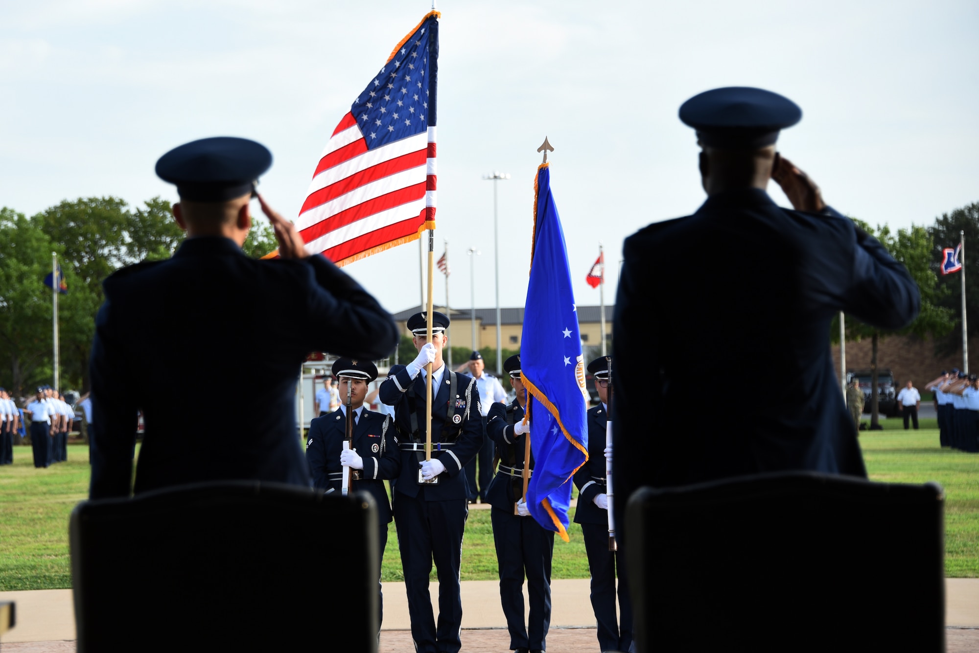 Brig. Gen. Lyle K. Drew, 82nd Training Wing incoming commander, and Brig. Gen. Kenyon K. Bell, 82nd TRW outgoing commander, render a salute during the national anthem at the Wing change of command ceremony, at Sheppard Air Force Base, Texas, July 15, 2021,. Maj. Gen. Andrea Tullos, 2nd Air Force commander, officiated the ceremony which gave the reins to the 82nd TRW to Drew.  Drew said he was replacing Bell, but following in his footsteps. (U.S. Air Force photo by Staff Sgt. Robert L. McIlrath)