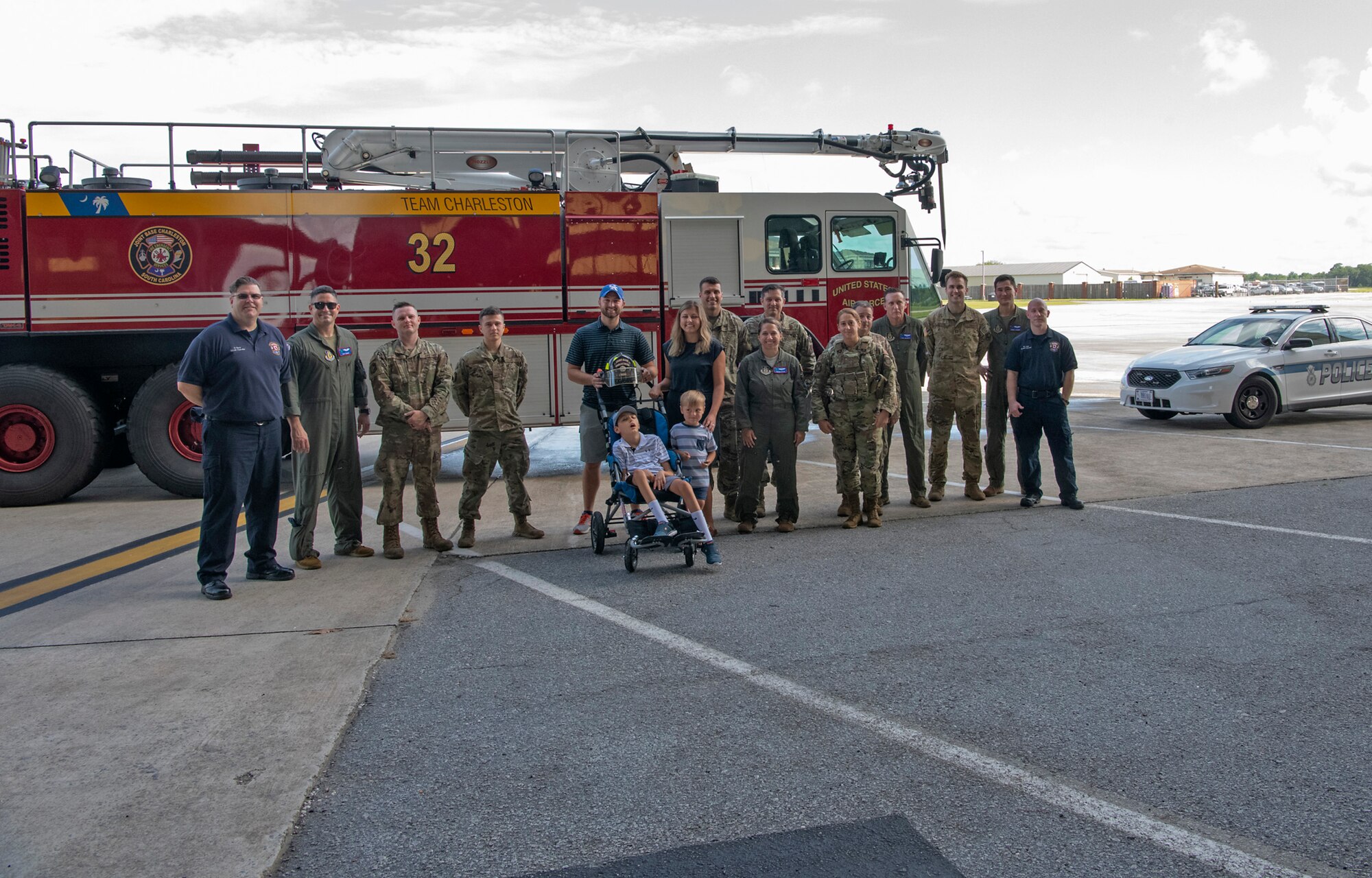 The Adkins family - Matt, Leslie, Braiden and Jace (center) pose for a group photo with aircrew, maintainers, firefighters and security forces at Joint Base Charleston, South Carolina.