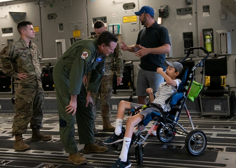 Master Sgt. James Ebert, 701st Airlift Squadron loadmaster, speaks with Braiden Adkins while touring a C-17 Globemaster III at Joint Base Charleston, South Carolina July 14, 2021.