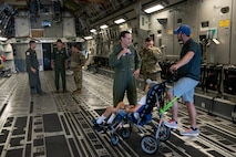 (From left) Master Sgt. James Ebert, 701st Airlift Squadron loadmaster, and Tech Sgt. Wade Griffith, 437th Maintenance Squadron, speak with Braiden and Matt Adkins while touring a C-17 Globemaster III at Joint Base Charleston, South Carolina July 14, 2021.