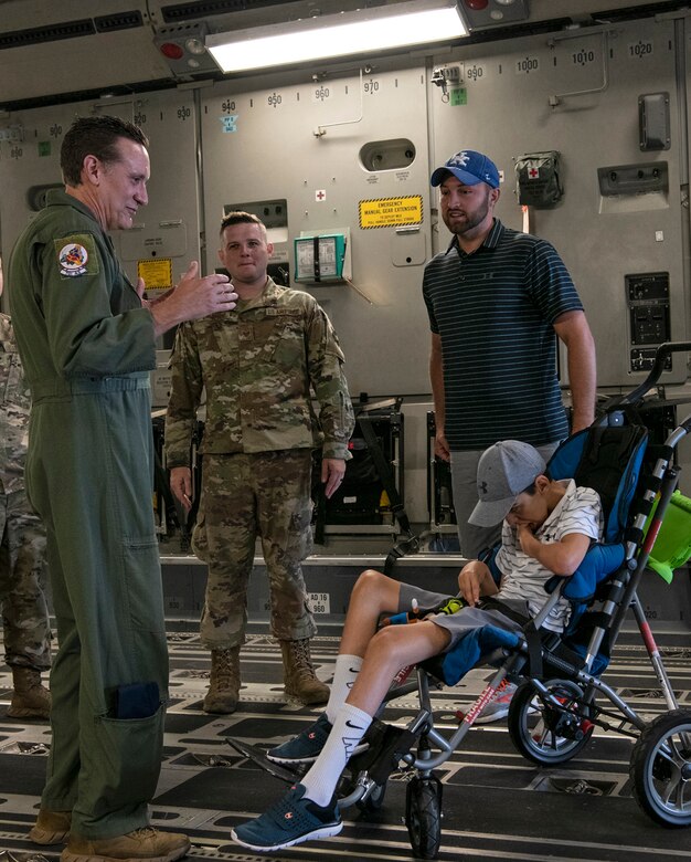 (From left) Master Sgt. James Ebert, 701st Airlift Squadron loadmaster, and Tech Sgt. Wade Griffith, 437th Maintenance Squadron, speak with Braiden and Matt Adkins while touring a C-17 Globemaster III at Joint Base Charleston, South Carolina July 14, 2021.