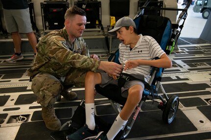 Tech Sgt. Wade Griffith, 437th Maintenance Squadron, gives a unit coin to Braiden Adkins while touring a C-17 Globemaster III at Joint Base Charleston, South Carolina July 14, 2021.