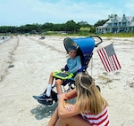 Airplane fan, Braiden Adkins and his mother Leslie enjoy the annual "Salute from the Shore" celebration in Charleston, South Carolina as a C-17 Globmaster III, flown by the 701st Airlift Squadron,  and other aircraft fly over the South Carolin Coast July 4, 2021