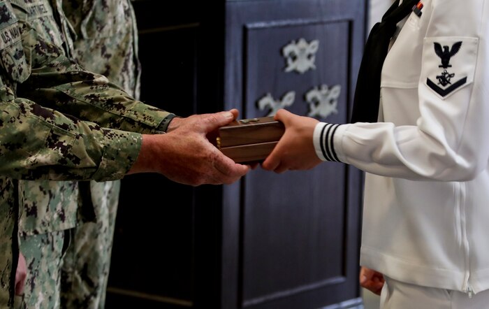 A member of Crewman Qualification Training (CQT) Class 115 receives a compass prior to a graduation ceremony at Naval Special Warfare (NSW) Center, July 15, 2021.