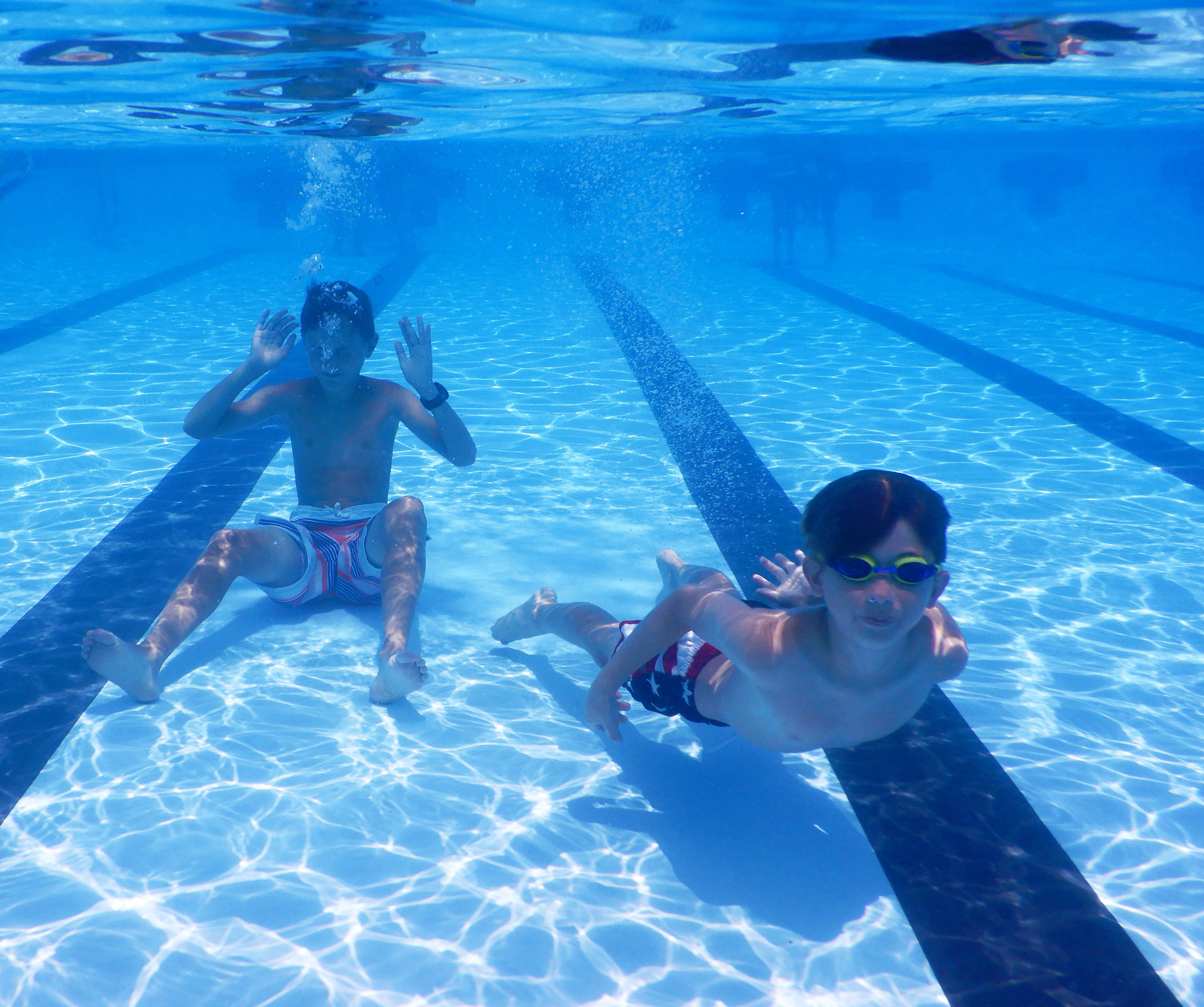 Cole Wexler, left, son of Master Sgt. Arik Wexler, 736th Aircraft Maintenance Squadron lead production superintendent, and Parker Evans, son of Tech. Sgt. Jason Evans, 436th Civil Engineer Squadron explosive ordnance disposal, swim underwater at the Oasis Pool at Dover Air Force Base, Del., July 14, 2021. During summer break, the pool is open 11 am to 7 pm daily for military members, family and friends. The pool no longer has block sessions for attendees, but has a capacity limit of 200 people.  (U.S. Air Force photo by Tech. Sgt. Nicole Leidholm)