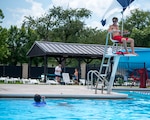 A lifeguard with the 436th Force Support Squadron, overlooks the Oasis Pool to ensure swimmers are safe at Dover Air Force Base, Del., July 14, 2021. During summer break, the pool is open 11 am to 7 pm daily for military members, family and friends. The pool no longer has block sessions for attendees, but has a capacity limit of 200 people.  (U.S. Air Force photo by Tech. Sgt. Nicole Leidholm)