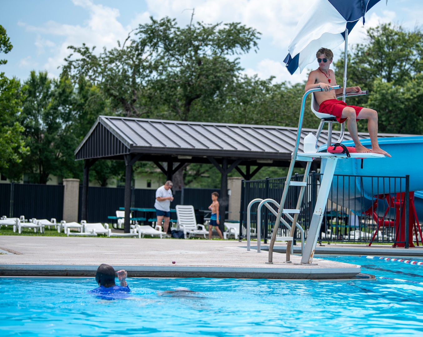 A lifeguard with the 436th Force Support Squadron, overlooks the Oasis Pool to ensure swimmers are safe at Dover Air Force Base, Del., July 14, 2021. During summer break, the pool is open 11 am to 7 pm daily for military members, family and friends. The pool no longer has block sessions for attendees, but has a capacity limit of 200 people.  (U.S. Air Force photo by Tech. Sgt. Nicole Leidholm)